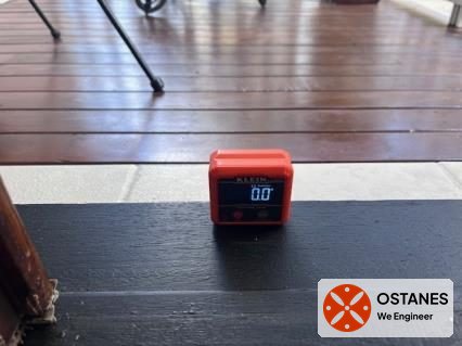 Digital level placed on timber balcony decking to measure fall