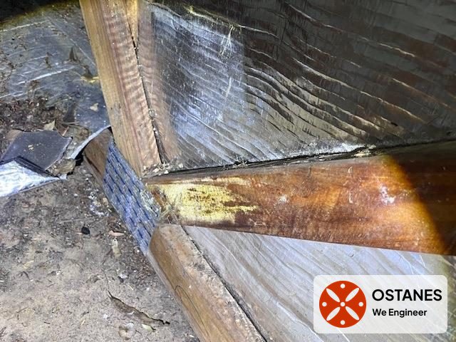 Water-stained timber roof framing with brownish residue