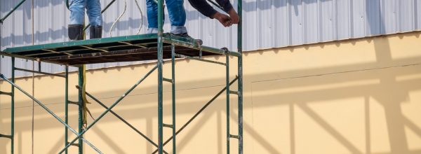 2-construction-workers-installing-high-scaffolding-for-construction-of-industrial-building-structure.jpg